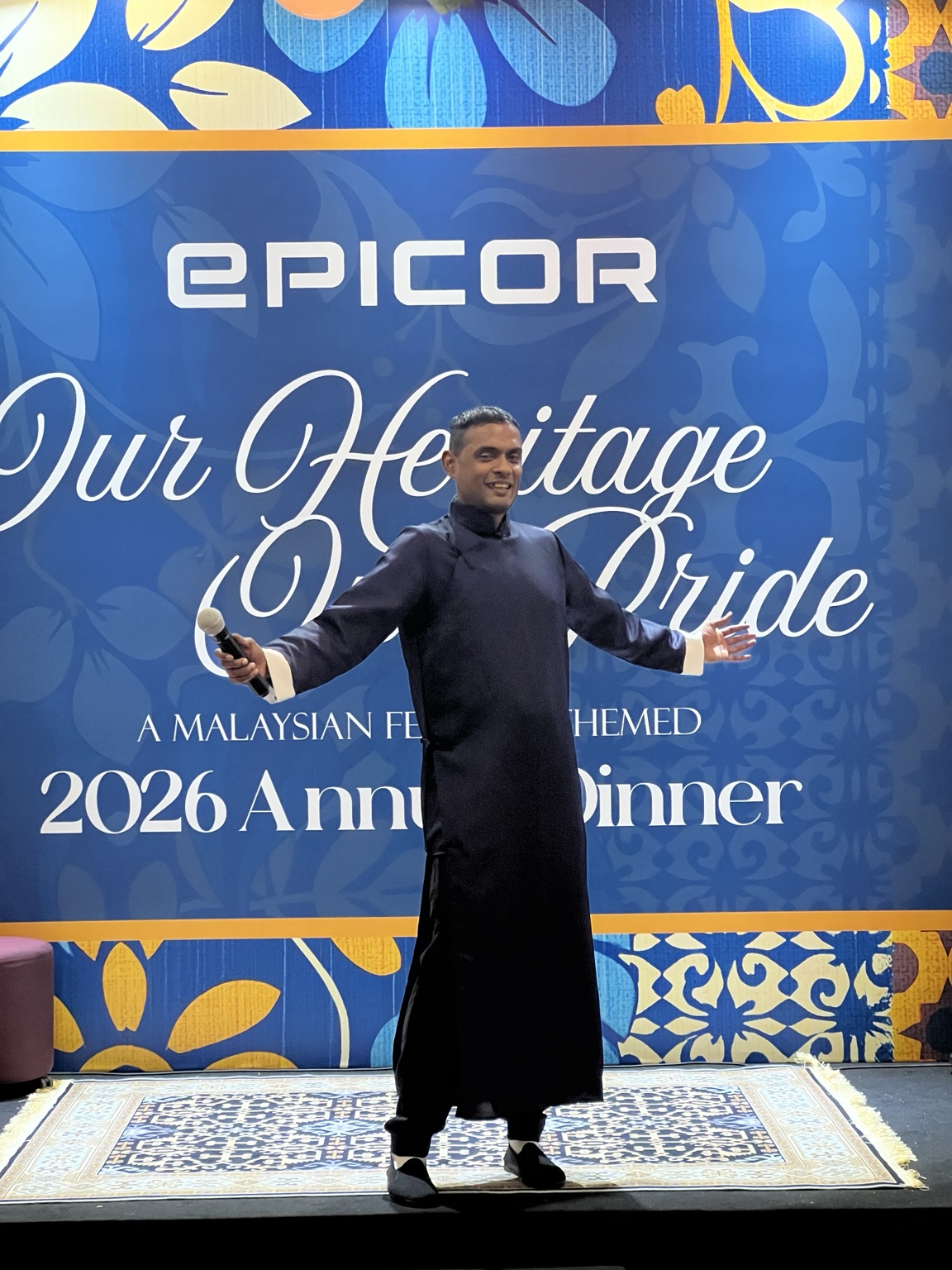 Adam Prakash holding a microphone at a corporate annual dinner